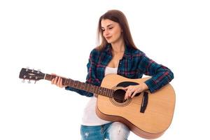 brunetta ragazza con chiuso occhi e chitarra nel mani foto