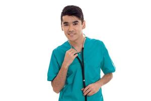 un' giovane medico nel il blu vestito con stetoscopio sorrisi e sembra in un' telecamera foto