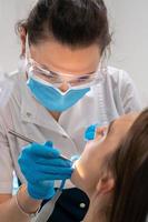 dentista ossequi denti per un' ragazza nel un' clinica foto