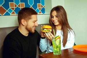 ragazza alimentazione sua fidanzato Hamburger foto