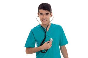 simpatico giovane maschio medico nel uniforme con statoscopio in posa isolato su bianca sfondo foto