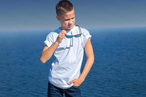 giovane ragazzo nel occhiali da sole a il spiaggia foto