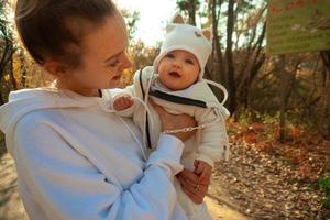 bellissimo giovane mamma con bambino nel autunno foto