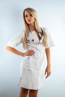 adulto bionda bellissimo infermiera nel bianca medico toga foto