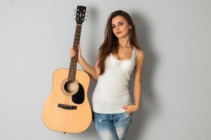 giovane brunetta donna con chitarra nel mani foto