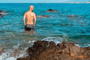 bello uomo su il marino roccioso riva foto