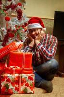 triste solitario nerd con un' mazzo di Natale i regali foto