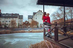 appassionato coppia nel amore abbracci su un' balcone inverno tempo foto