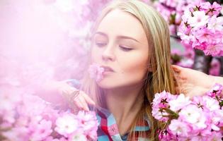 luminosa affascinante donna con fiore nel bocca foto