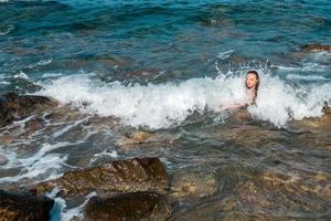 contento giovane signora nuotate a il mare foto