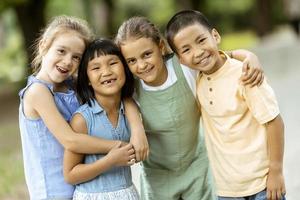 gruppo di asiatico e caucasico bambini avendo divertimento nel il parco foto