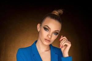 bellissimo giovane ragazza nel blu giacca con bellezza trucco nel studio foto