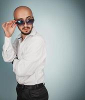 carino uomo nel occhiali da sole con barba guardare lontano foto