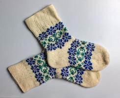 bianca lana calzini con blu verde fatto a mano argentino merino lana su un' bianca sfondo. foto