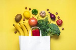 eco amichevole carta negozio Borsa con crudo biologico verde verdure isolato su giallo sfondo piatto posizione, superiore Visualizza zero sciupare, plastica gratuito concetto salutare pulito mangiare dieta e disintossicazione, agricoltura concetto foto