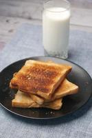 bicchiere di latte e tostato pane su tavolo foto