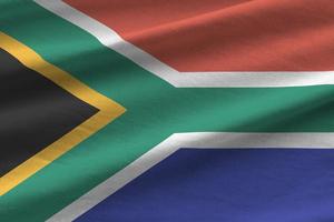 Sud Africa bandiera con grande pieghe agitando vicino su sotto il studio leggero al chiuso. il ufficiale simboli e colori nel bandiera foto