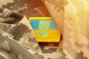 militare camuffare tessuto con ucraino bandiera su uniforme gallone foto