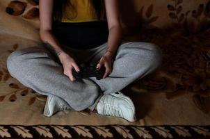 un' giovane ragazza giochi video Giochi con un' nero telecomando da gioco con molti B foto