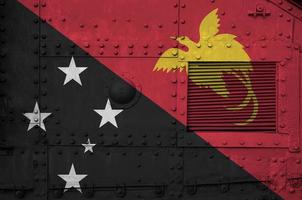 papua nuovo Guinea bandiera raffigurato su lato parte di militare blindato serbatoio avvicinamento. esercito forze concettuale sfondo foto