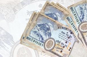 500 nepalese rupie fatture bugie nel pila su sfondo di grande semi trasparente banconota. astratto presentazione di nazionale moneta foto