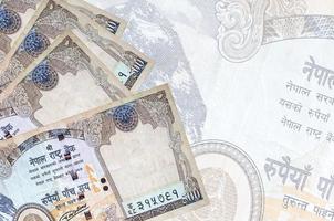 500 nepalese rupie fatture bugie nel pila su sfondo di grande semi trasparente banconota. astratto attività commerciale sfondo foto