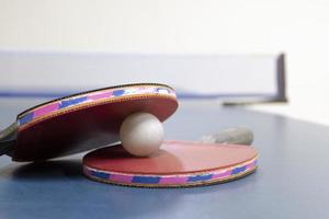 ping pong racchette e palle su tavolo foto
