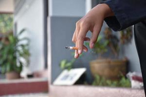 ragazzo apprendimento per Fumo di lui stesso nel il la zona dietro a il scuola recinto quale è un' nascosto posto per le persone, cattivo influenza di secondario scuola o junior alto scuola vita, dipendenza. foto