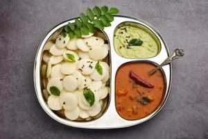 mini idli è il più piccolo versione di morbido e spugnoso il giro sagomato al vapore regolare riso idli, anche conosciuto come pulsante e cocktail folle foto