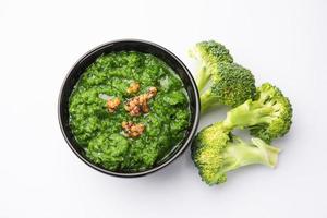 fresco broccoli chutney o incolla, puré nel il ciotola con crudo pezzi foto