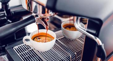 caffè estrazione a partire dal il caffè macchina con un' portafilter scrosciante caffè in un' tazza, caffè espresso scrosciante a partire dal caffè macchina a il caffè negozio foto