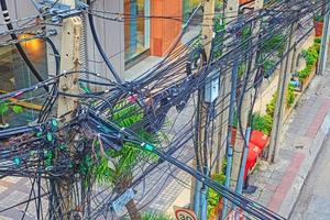 caotico cavo instradamento di elettricità e telefono cavi su un' principale strada nel bangkok foto