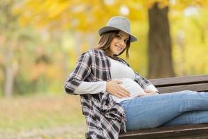 giovane donna incinta nel parco d'autunno foto