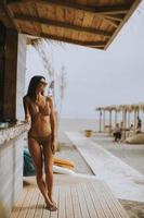 giovane donna in bikini in piedi vicino al bar della spiaggia in una giornata estiva foto