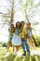 gruppo di asiatico e caucasico bambini avendo divertimento nel il parco foto