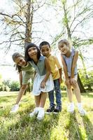 gruppo di asiatico e caucasico bambini avendo divertimento nel il parco foto