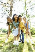 gruppo di asiatico e caucasico bambini avendo divertimento nel il parco foto