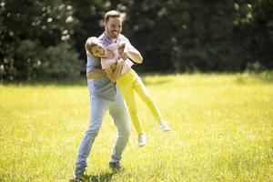 padre che insegue la sua piccola figlia mentre gioca nel parco foto