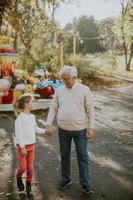 nonno che si diverte con la nipotina al luna park foto