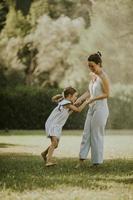 carino poco ragazza avendo divertimento su un' erba con sua madre foto