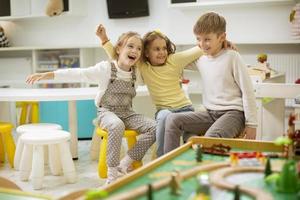 gruppo di scuola materna ragazzo amici seduta e avendo divertimento foto