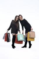 Due contento femmina amici con shopping Borsa su isolato studio sfondo. foto