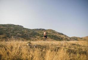 sportivo uomo corridore in esecuzione su montagna altopiano nel estate foto