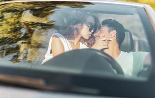 amici avendo divertimento a auto viaggio in giro il mondo. coppia nel amore con braccia su su un' convertibile macchina. foto