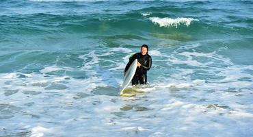 bellissimo surfer ragazza su il spiaggia foto