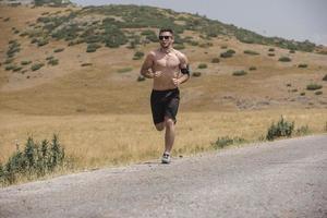 sportivo uomo corridore in esecuzione su montagna altopiano nel estate foto