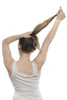 femmina modello organizzazione sua capelli. donna legatura capelli nel un' panino. foto