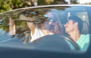 amici avendo divertimento a auto viaggio in giro il mondo. coppia nel amore con braccia su su un' convertibile macchina. foto