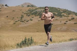 sportivo uomo corridore in esecuzione su montagna altopiano nel estate foto