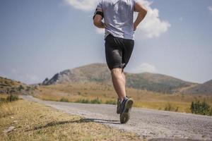 sportivo uomo corridore in esecuzione su montagna altopiano nel estate foto